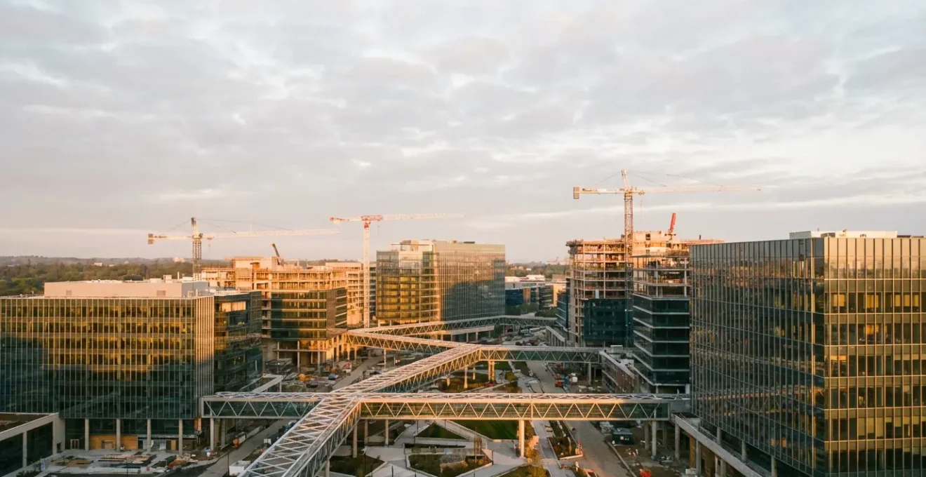 Vue aérienne d'un campus tech moderne en pleine expansion avec grues de construction et architecture futuriste, symbolisant la croissance rapide des licornes