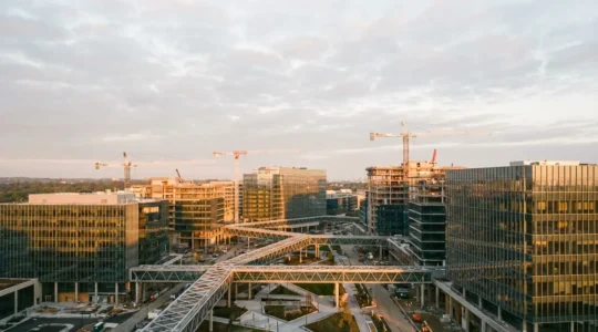 Vue aérienne d'un campus tech moderne en pleine expansion avec grues de construction et architecture futuriste, symbolisant la croissance rapide des licornes